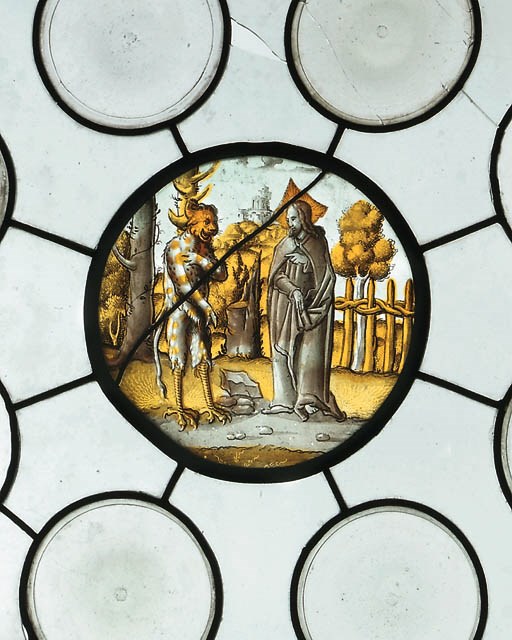 A SQUARE STAINED GLASS PANEL DEPICTING THE TEMPTATION OF CHRIST