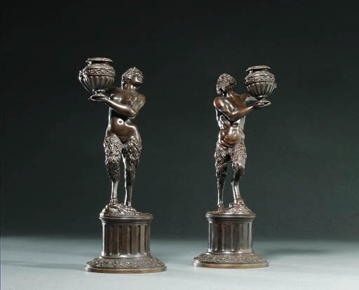 A PAIR OF BRONZE CANDLESTICKS IN THE FORM OF A STANDING SATYR AND SATYRESS