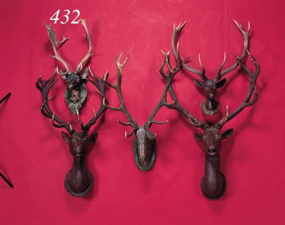 two carved wooden heads of deer