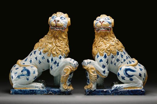 A PAIR OF ROUEN FAIENCE MODELS OF SEATED HERALDIC LIONS