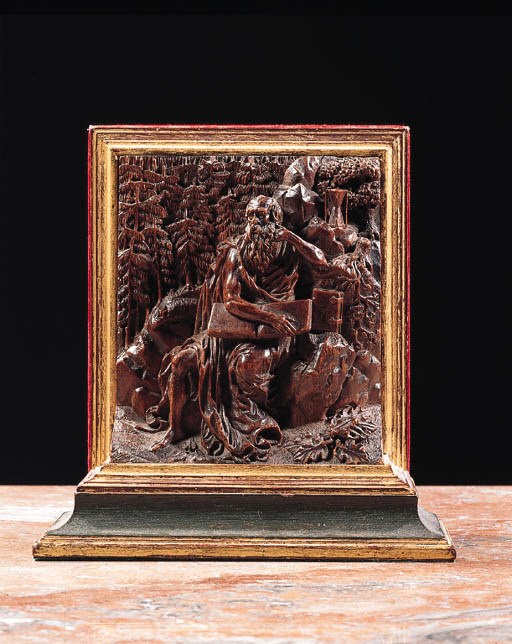A carved wooden relief of a seated hermit, possibly Saint Jerome