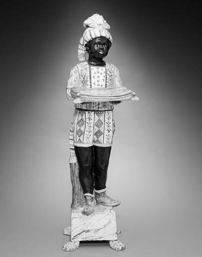 A CONTINENTAL TIN-GLAZED EARTHENWARE FIGURE OF A BLACKAMOOR