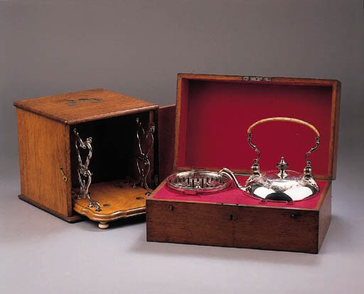 An English silver teakettle on a Dutch silver and wooden stand and lamp