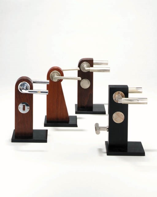 A GROUP OF NICKELED-METAL AND BRASS DOOR HANDLES AND LOCK PLATES