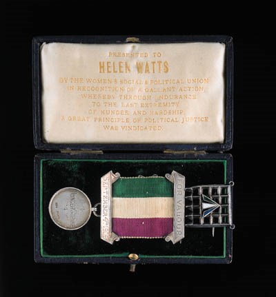 THE WOMEN'S SOCIAL AND POLITICAL UNION'S MEDAL FOR VALOUR, silver (Hallmarks for Birmingham, 1909), prepared by Toye, Theobald's Road, London, obverse engraved, 'Hunger Strike', reverse engraved, 'Helen Watts', within raised border, with suspension bar engraved,  'September 4th 1909' and upper wearing brooch, 'For Valour', 22mm.,  good very fine and rare, contained in original leather box of  issue, the inner lid of white silk bearing a gold lettered  inscription, 'Presented to Helen Watts by the Women's Social and  Political Union in Recognition of a Gallant Action, Whereby Through  Endurance to the Last Extremity of Hunger and Hardship, A Great  Principle of Political Justice was Vindicated', together with   Suffragette's 'Portcullis Badge', silver and enamel, this last   lacking usual chain attachments