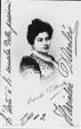 DARCLÉE, Hariclea (nome d'arte di Haricela Haricly de Hartulary, 1868-1939). Due fotografie con firma autografa della grande soprano rumena, entrambe al recto di cartoline postali: una la ritrae in abito di scena per Tosca, l'altra (Roma, Felicetti) reca anche un pensierino ("L'Arte è la scuola delle passioni!") e la data (1903) autografi.	 (2)
