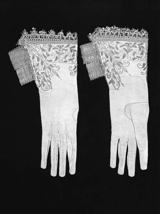 A pair of gentleman's gauntlets, of doeskin, the cuffs embroidered in gold thread with scrolling leaves and trimmed with sequins, edged with gold lace trimmed with sequins, lined with claret coloured silk, the back slits bridged by two folded bands of claret coloured silk trimmed with gold lace - English, circa 1640