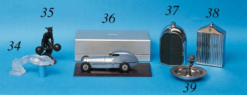 Bentley - A decorative table decanter by "Ruddspeed", in the form of a 3-litre Bentley radiator; chrome-plated with radiator cap filler and enamel badge to front, English c1960. Height 8ins (20cm)