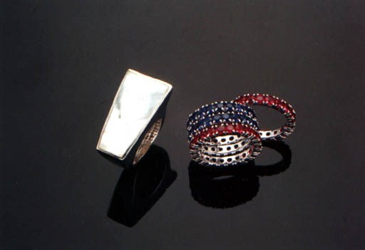 A SET OF FOUR RUBY AND SAPPHIRE ETERNITY BANDS AND A MOTHER-OF-PEARL RING