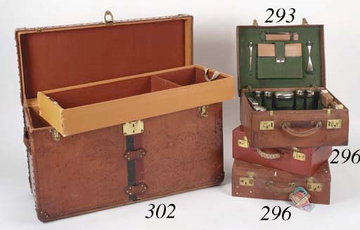 A Louis Vuitton gentleman's shoe trunk, covered in natural cow hide and bound in leather and brass with brass rivets, monogrammed T.I.V beneath a coronet on the sides, with black and burgundy owner stripes, the interior fitted with two trays lined with brown felt, one with a section for polishing equipment, labelled Louis Vuitton Paris London Nice Lille 767047--37 x 15 1/2 x 21in. (94 x 39 x 53cm.), circa 1920, some wear and staining to the leather