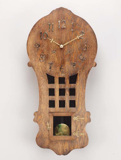 An Arts and Crafts wooden and brass wall clock