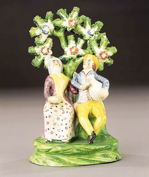 A creamware group of a male drinker and companion
