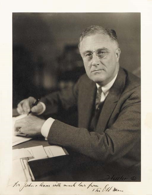 ROOSEVELT, Franklin D. Photograph of President Roosevelt inscribed and signed ("The Old Man"), Washington, D.C., ca. 1942. 13½ x 10½ in., ink copyright notice of the photographer, Hessler at lower right, later frame. A strong image of the President, seated at a desk in the White House, pen in hand. INSCRIBED BY FDR to John A. Roosevelt and his first wife in ink in lower margin: "To John and Anne with much love from The Old Man."