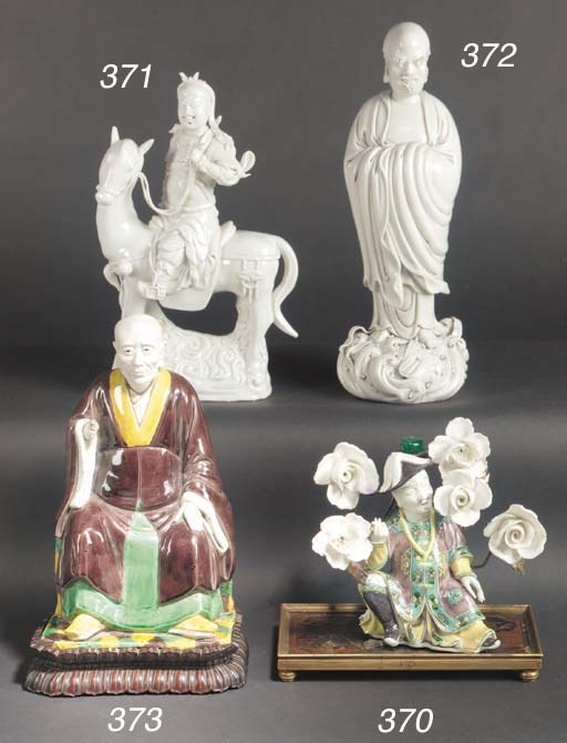 A famille verte biscuit model of a seated gentleman
Kangxi