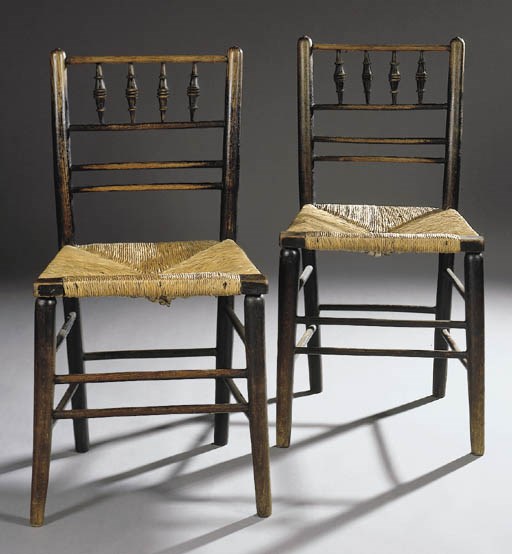 A pair of 'Sussex' ebonised armchairs