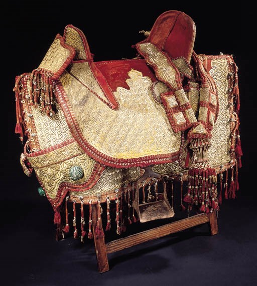 A leather saddle and embroidered cover,