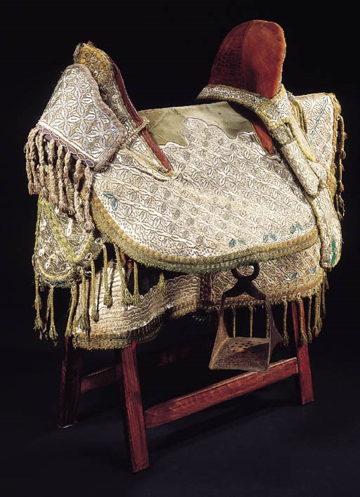A leather saddle and embroidered cover,