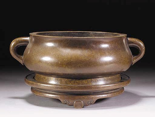 A Chinese bronze bombe censer and stand
18th Century