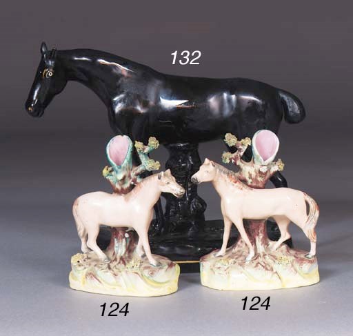 A pair of Staffordshire horse spill vases