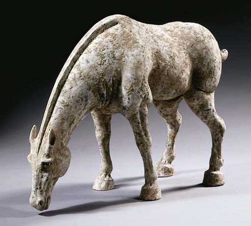 A painted grey pottery figure of a grazing horse