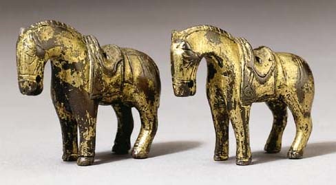A pair of gilt bronze figures of horses and a bronze model of a lion