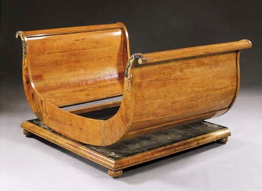 AN EMPIRE PARCEL-EBONIZED AND GILT MAHOGANY SLEIGH BED
