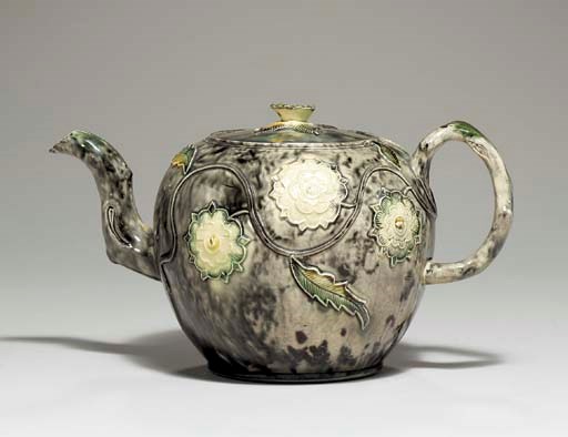 A STAFFORDSHIRE CREAMWARE GLOBULAR TEAPOT AND COVER