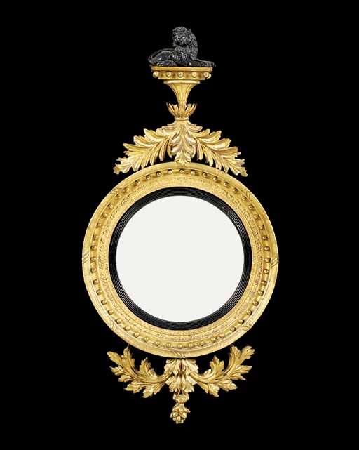 An ebonised and carved giltwood convex mirror, parts early 19th century