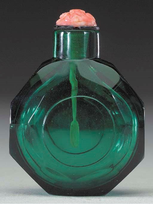 A FACETED GREEN GLASS BOTTLE