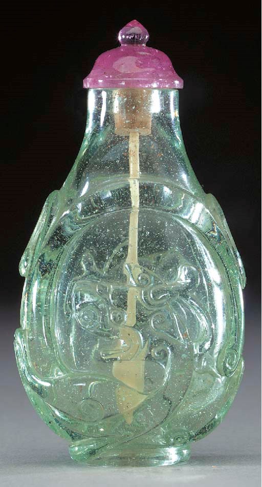A CARVED PALE GREEN GLASS BOTTLE