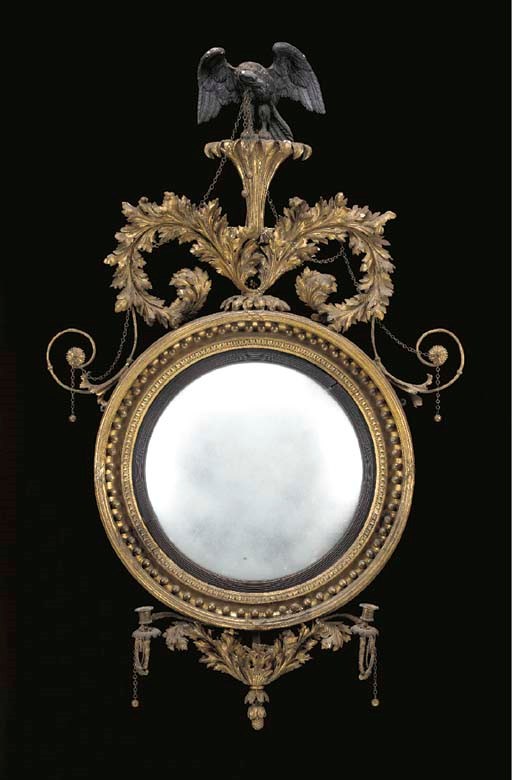 A REGENCY GILTWOOD AND EBONIZED CONVEX GIRANDOLE MIRROR