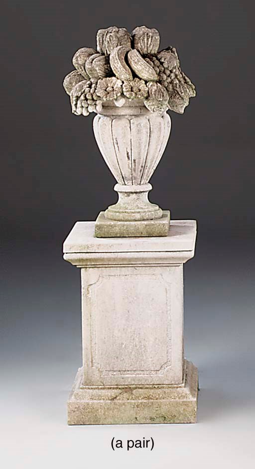 A pair of carved limestone flower-filled urn-shaped vases