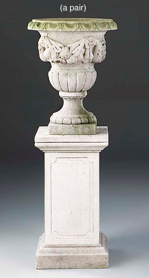 A pair of carved limestone urns