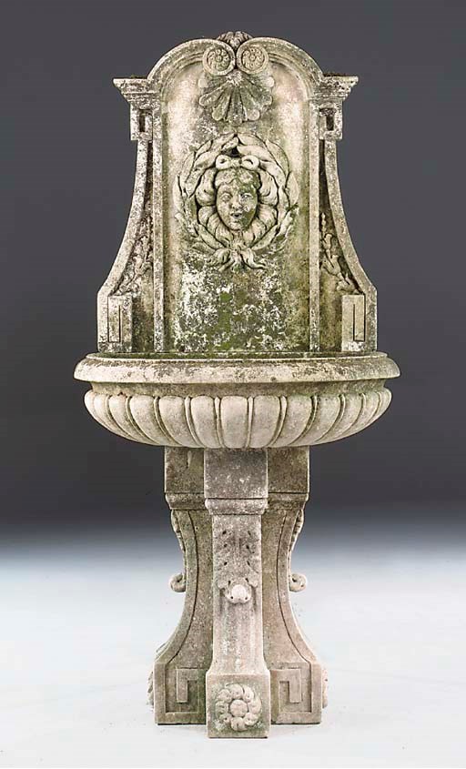 A carved limestone wall fountain