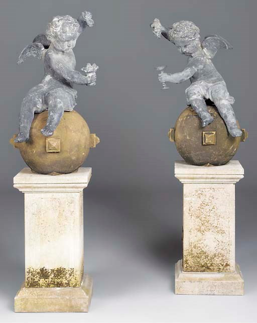 A pair of cast lead cherubs on sculpted stone spheres, 20th century