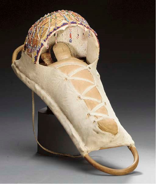 AN APACHE BEADED HIDE DOLL CRADLEBOARD
