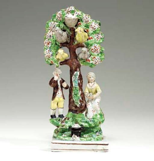 A STAFFORDSHIRE PEARLWARE FIGURE GROUP OF A FARMER AND HIS WIFE