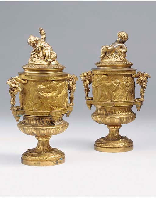 A pair of French gilt metal twin handled urns with covers, late 19th century