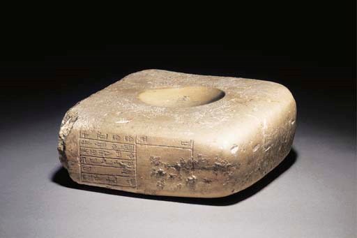 A BABYLONIAN INSCRIBED CREAM STONE DOOR SOCKET