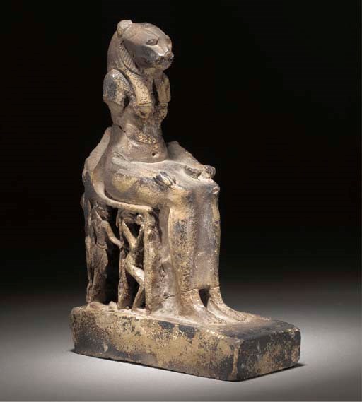 AN EGYPTIAN FAIENCE SEATED STATUETTE OF SEKHMET