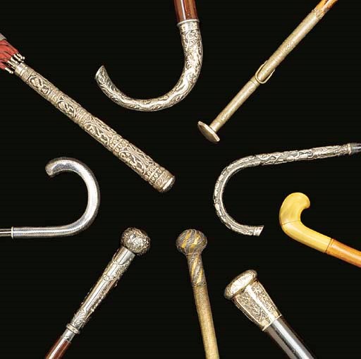 A collection of five walking sticks and four umbrellas
