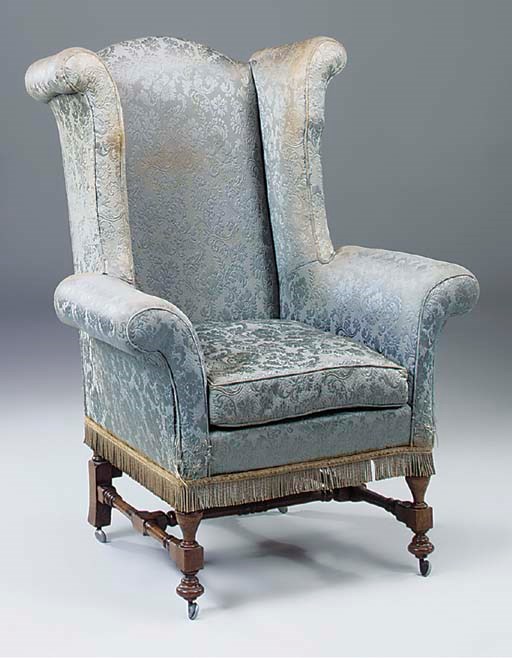 A large green upholstered wing armchair