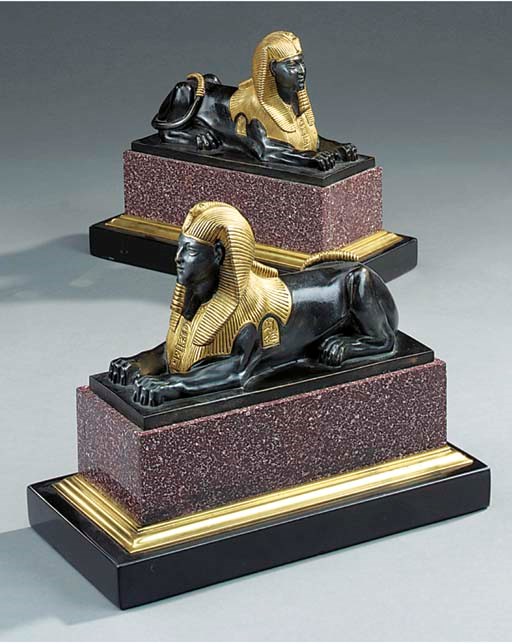 A pair of parcel gilt bronze and porphyry mounted models of sphinxes
