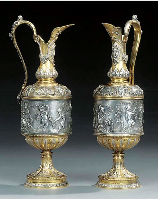 A pair of Victorian parcel silvered and gilt metal ewers