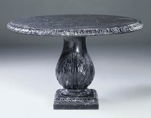 A carved variegated black and white marble circular table