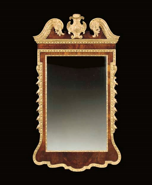 A GEORGE II PARCEL-GILT AND WALNUT MIRROR,