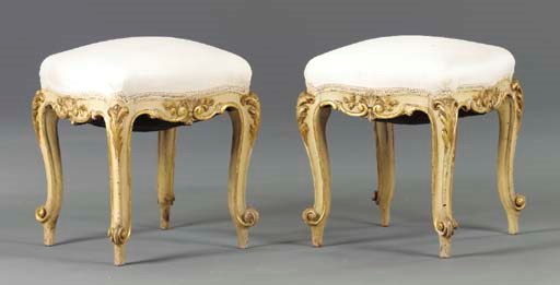 A PAIR OF ITALIAN ROCOCO STYLE CREAM PAINTED AND PARCEL-GILT STOOLS,