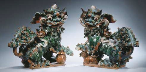 A pair of enamelled figures of buddhistic lions