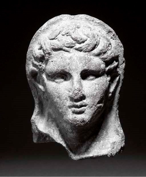 AN ETRUSCAN TERRACOTTA VOTIVE HEAD OF A YOUTH