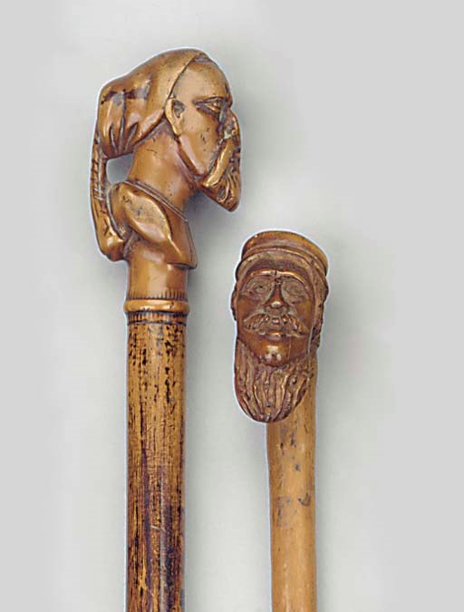 A stained wood walking stick mounted with a carved boxwood grip